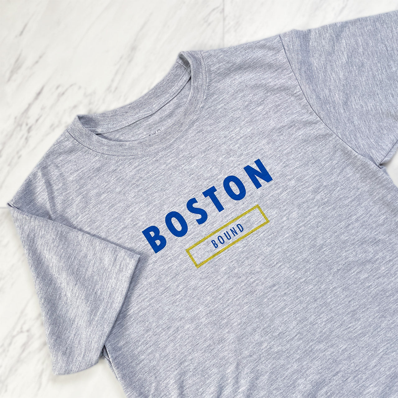 Boston Bound performance short sleeve shirt from TWO CORRALS Lifestyle Running Brand, minimalistic Boston Bound tee with text printed in blue ink and a yellow outline box around the word bound