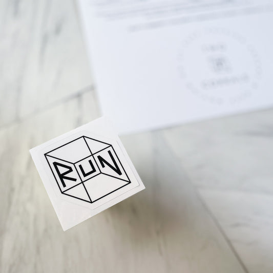 RUN sticker from TWO CORRALS Lifestyle Running Brand, minimalistic running sticker in our signature RUN cube design printed in black ink and background in white