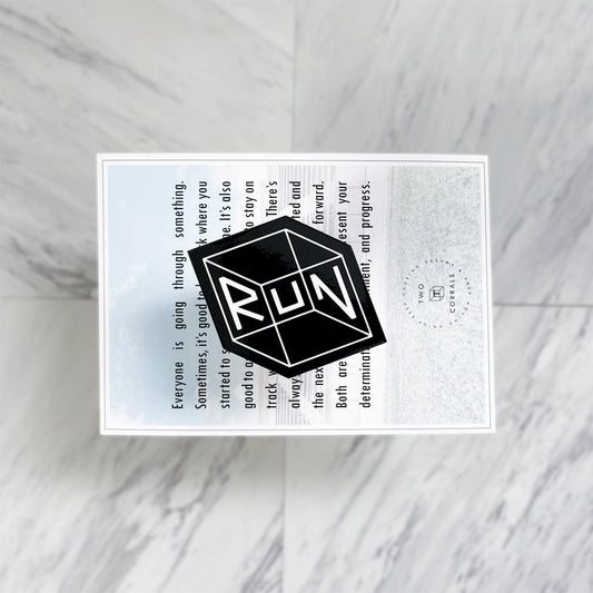 Black RUN sticker from TWO CORRALS Lifestyle Running Brand, minimalistic running sticker in our signature RUN cube design in white and background in black